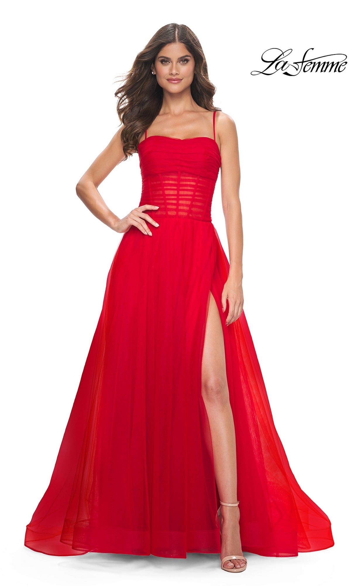 A woman stands confidently with one hand on her hip, wearing the La Femme Sheer-Waist Long Prom Ball Gown 32017—a sleeveless, floor-length A-line dress with a sheer bodice and high slit. The La Femme logo appears in the top right corner.